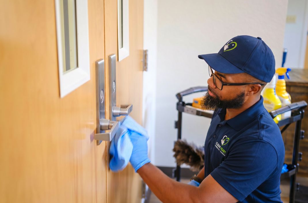 Clean Heart team member disinfecting a high-touch door handle in Orlando